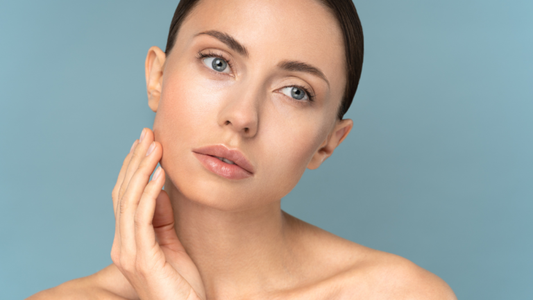 Woman with glowing skin touching her face