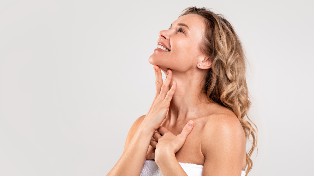 Woman smiling while touching her chin and smiling after Double chin Treatment
